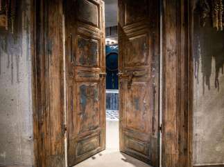 Step through these magnificent, antique wooden double doors, showcasing intricate carvings and a distressed finish that adds character and history.