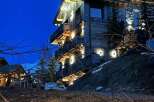 Experience luxury mountain living in this stunning chalet, featuring a rustic wooden exterior complemented by stone accents.