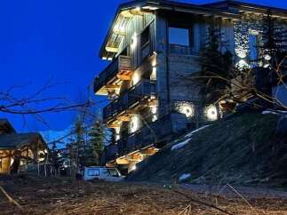 Experience luxury mountain living in this stunning chalet, featuring a rustic wooden exterior complemented by stone accents.