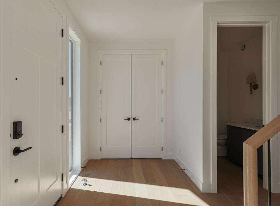 Step into a bright and airy entryway featuring a modern smart lock on the front door and a sleek, minimalist design.