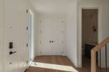 Step into a bright and airy entryway featuring a modern smart lock on the front door and a sleek, minimalist design.