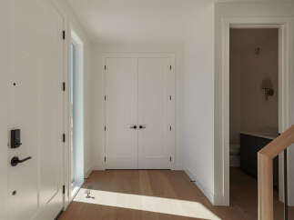 Step into a bright and airy entryway featuring a modern smart lock on the front door and a sleek, minimalist design.