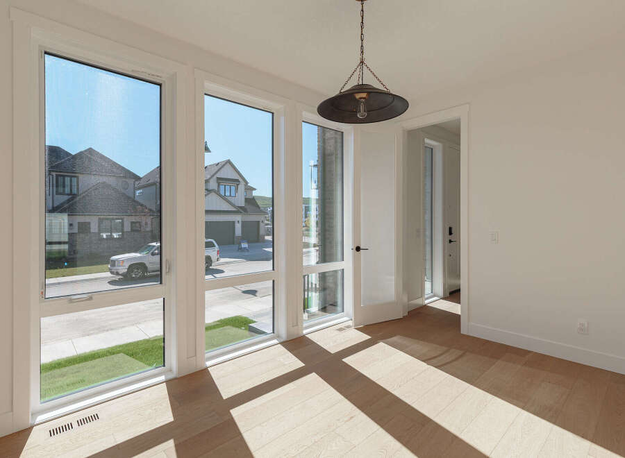 Bathed in natural light, this room boasts expansive windows offering picturesque views of the neighborhood's modern architecture and well-maintained lawns.