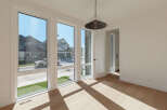 Bathed in natural light, this room boasts expansive windows offering picturesque views of the neighborhood's modern architecture and well-maintained lawns.