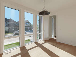 Bathed in natural light, this room boasts expansive windows offering picturesque views of the neighborhood's modern architecture and well-maintained lawns.