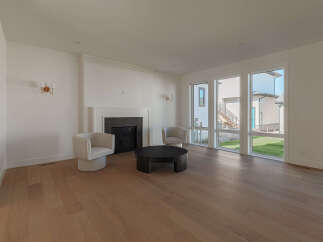 Step into this bright and airy living room, featuring a modern fireplace as the focal point.