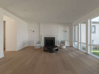 Step into this bright and airy living room, featuring a modern fireplace as the focal point.