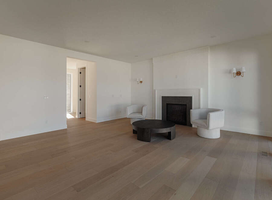 Step into this inviting living room, featuring a modern fireplace as the focal point and two plush armchairs perfect for relaxation.