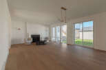 Experience modern living in this spacious great room, featuring a sleek fireplace and ample natural light from large windows.