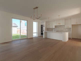 Experience modern living in this spacious open-concept home, featuring a sleek white kitchen with ample cabinet space and a large island perfect for entertaining.