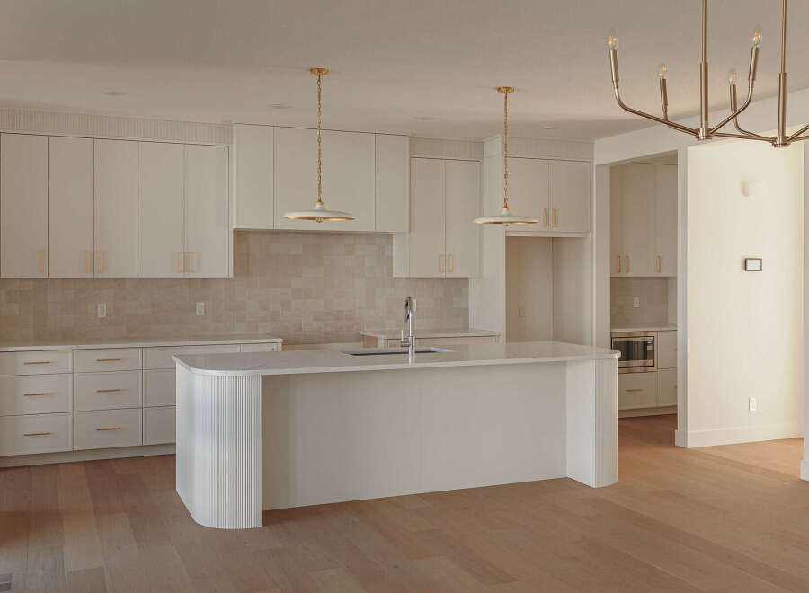 Experience modern luxury in this stunning kitchen featuring sleek white cabinetry with elegant gold hardware.