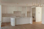 Experience modern luxury in this stunning kitchen featuring sleek white cabinetry with elegant gold hardware.