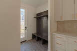 This mudroom features a dark wood built-in bench with a shelf and coat hooks, perfect for organizing entryways.