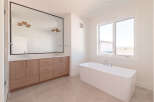 Experience luxury in this modern bathroom, featuring a spacious double vanity with ample storage and a sleek, freestanding soaking tub.