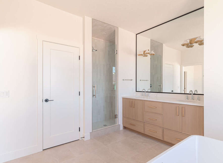 This modern bathroom features a spacious glass-enclosed shower with tiled walls and a sleek showerhead.