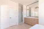 This modern bathroom features a spacious glass-enclosed shower with tiled walls and a sleek showerhead.