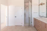 Step into this modern bathroom featuring a spacious glass-enclosed shower with a rainfall showerhead and a handheld wand.
