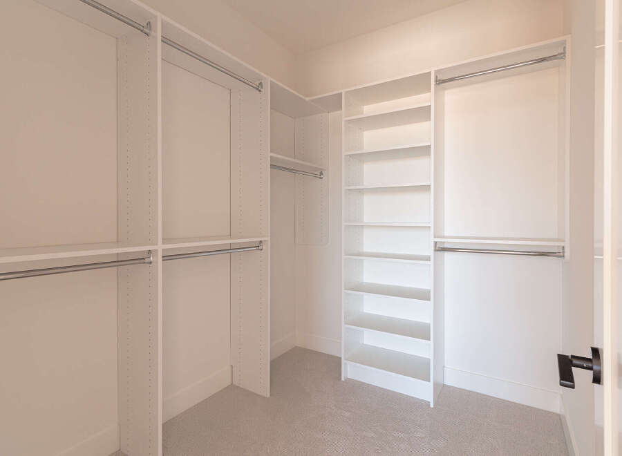 Step into this spacious walk-in closet, designed for ultimate organization and style.