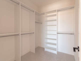 Step into this spacious walk-in closet, designed for ultimate organization and style.