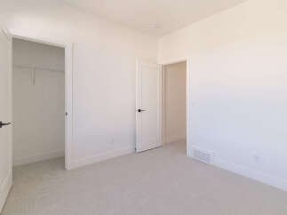 Step into this bright and airy bedroom, featuring a spacious walk-in closet with ample shelving for all your storage needs.