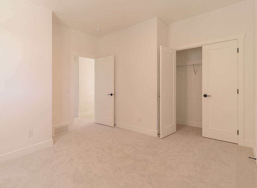 Step into this beautifully appointed bedroom, featuring plush carpeting and neutral-toned walls that create a serene atmosphere.