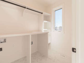 This spacious laundry room features a built-in countertop and shelving, perfect for organizing your laundry essentials.