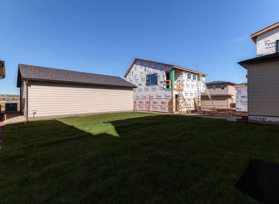 This property showcases a new construction home in its framing stages, wrapped in Tyvek for weather protection.