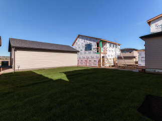 This property showcases a new construction home in its framing stages, wrapped in Tyvek for weather protection.