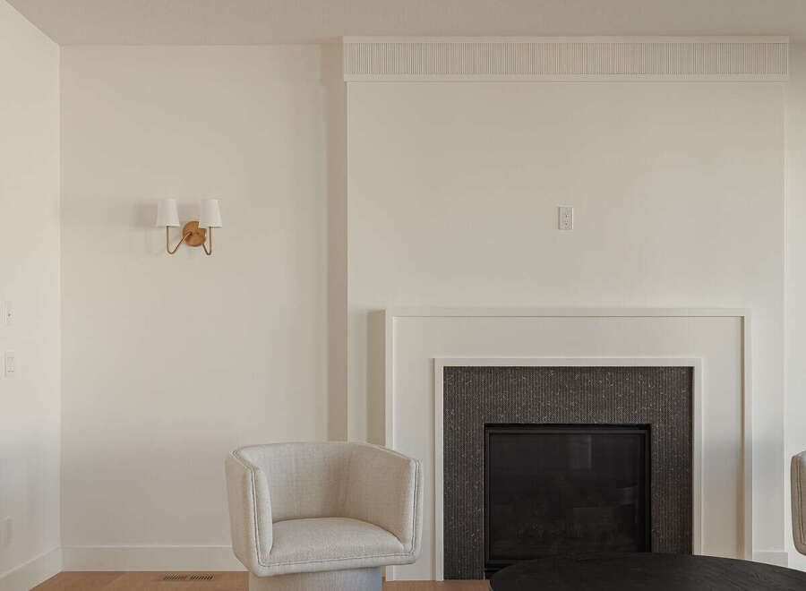 Experience modern living in this beautifully appointed living room, featuring a sleek fireplace with a dark tiled surround and a minimalist mantelpiece.