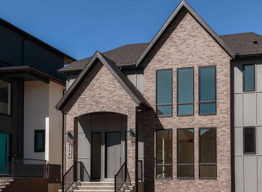 Discover modern living in this stunning new construction home, featuring a striking brick facade and expansive windows that flood the interior with natural light.