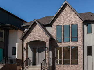 Discover modern living in this stunning new construction home, featuring a striking brick facade and expansive windows that flood the interior with natural light.