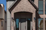 This modern home features a striking facade with a combination of brick and vertical siding.