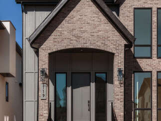 This modern home features a striking facade with a combination of brick and vertical siding.