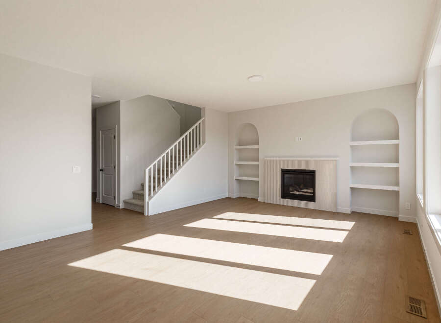 Step into this bright and airy living room, featuring a modern gas fireplace with a fluted tile surround and built-in arched shelving.