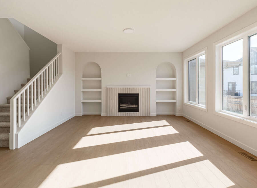 Step into this bright and airy living space, featuring a modern fireplace with a decorative tiled surround and built-in arched shelving.