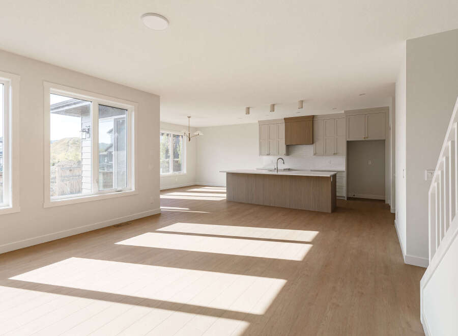 Experience modern living in this spacious open-concept home, featuring a sleek kitchen with a large island and ample cabinet space.