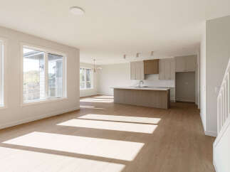 Experience modern living in this spacious open-concept home, featuring a sleek kitchen with a large island and ample cabinet space.