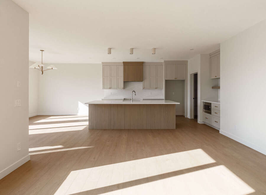 Discover this stunning, modern kitchen featuring a spacious island with a waterfall countertop, perfect for meal prep and entertaining.