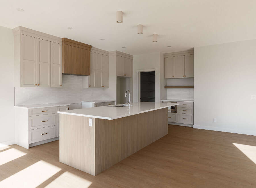 This modern kitchen boasts a spacious island with a built-in sink, perfect for meal preparation and casual dining.