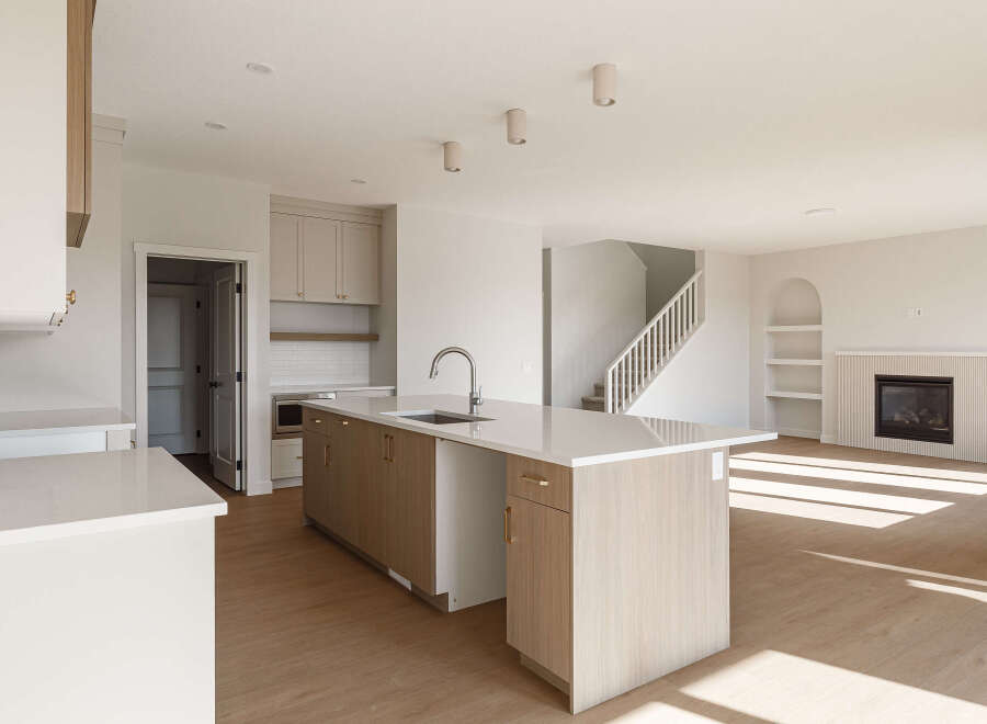 Experience modern living in this spacious open-concept home, featuring a sleek kitchen with a large island and ample cabinet space.