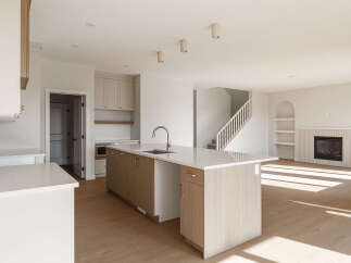 Experience modern living in this spacious open-concept home, featuring a sleek kitchen with a large island and ample cabinet space.