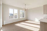 Bathed in natural light, this spacious room features large windows offering scenic views and a modern chandelier.