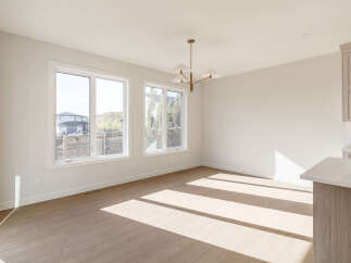 Bathed in natural light, this spacious room features large windows offering scenic views and a modern chandelier.