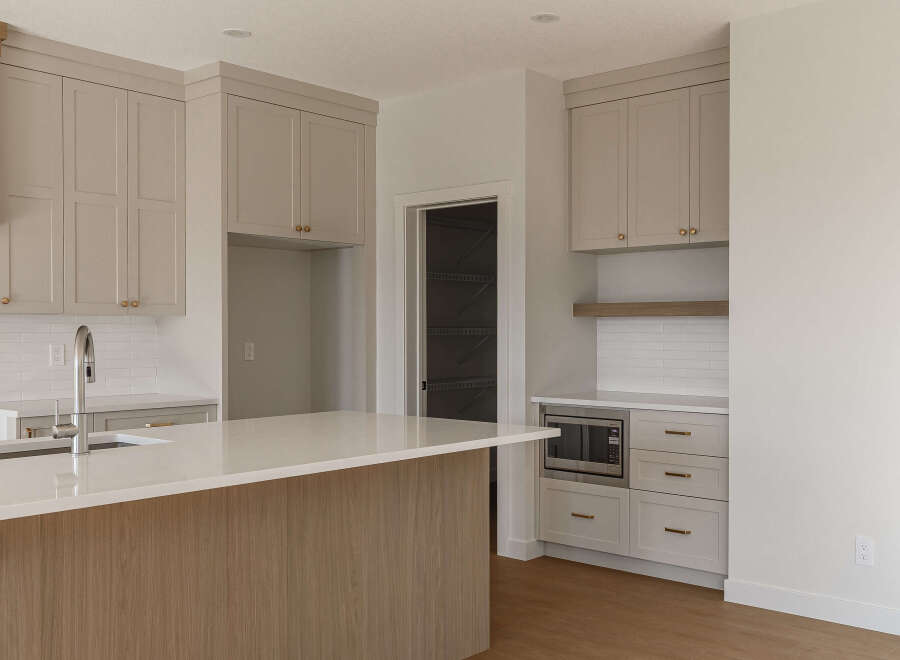 Experience modern living in this stunning kitchen featuring sleek, light-colored cabinetry with elegant brass hardware.