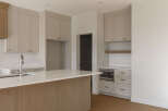 Experience modern living in this stunning kitchen featuring sleek, light-colored cabinetry with elegant brass hardware.