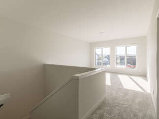 Step into this bright and airy upper-level living space, featuring a neutral color palette and plush carpeting for ultimate comfort.