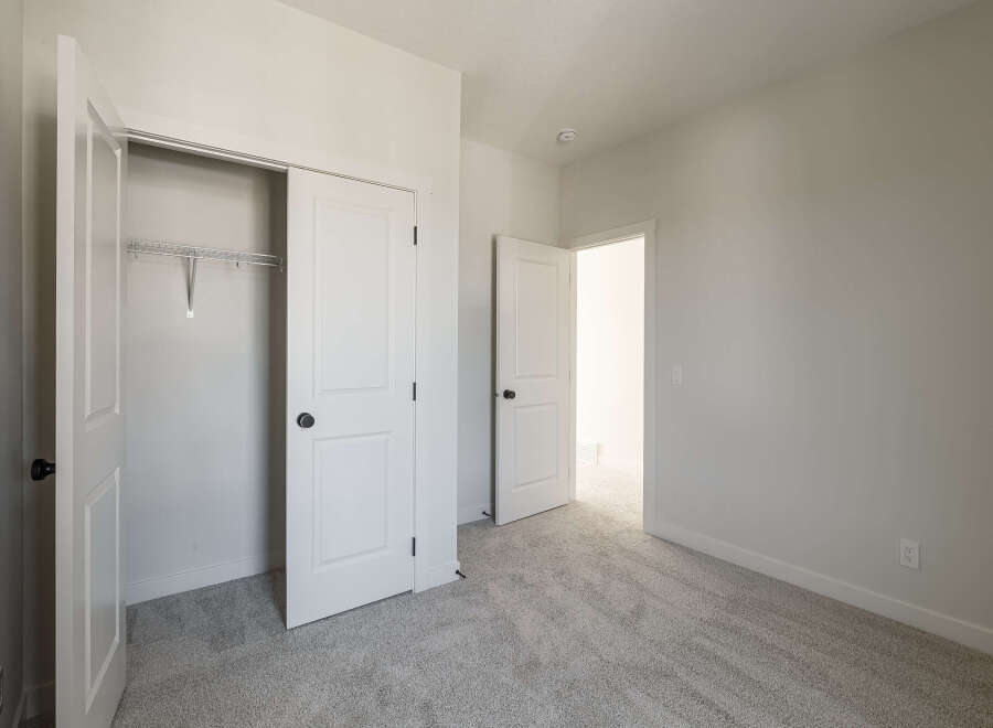 Step into this bright and airy bedroom, featuring a spacious closet with a wire shelving system ready for your organizational needs.
