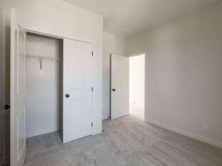 Step into this bright and airy bedroom, featuring a spacious closet with a wire shelving system ready for your organizational needs.