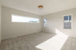 Discover this bright and airy bedroom, featuring a large horizontal window that floods the space with natural light.