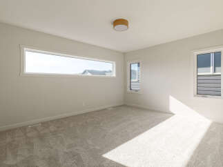 Discover this bright and airy bedroom, featuring a large horizontal window that floods the space with natural light.